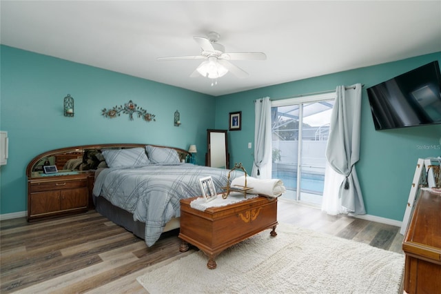 bedroom with hardwood / wood-style floors, access to outside, and ceiling fan