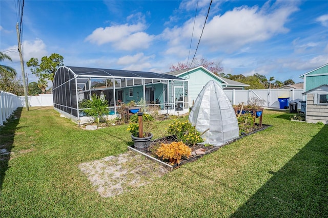 back of house with a lanai and a lawn