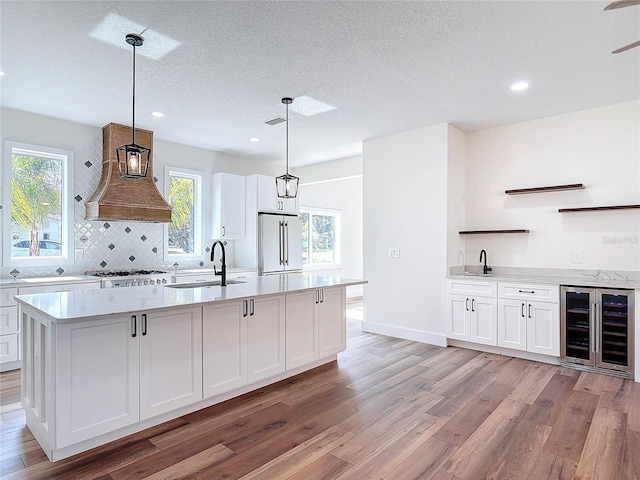 kitchen with white cabinetry, pendant lighting, and high end refrigerator