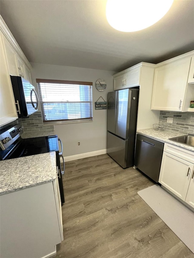 kitchen featuring white cabinetry, light hardwood / wood-style flooring, and appliances with stainless steel finishes