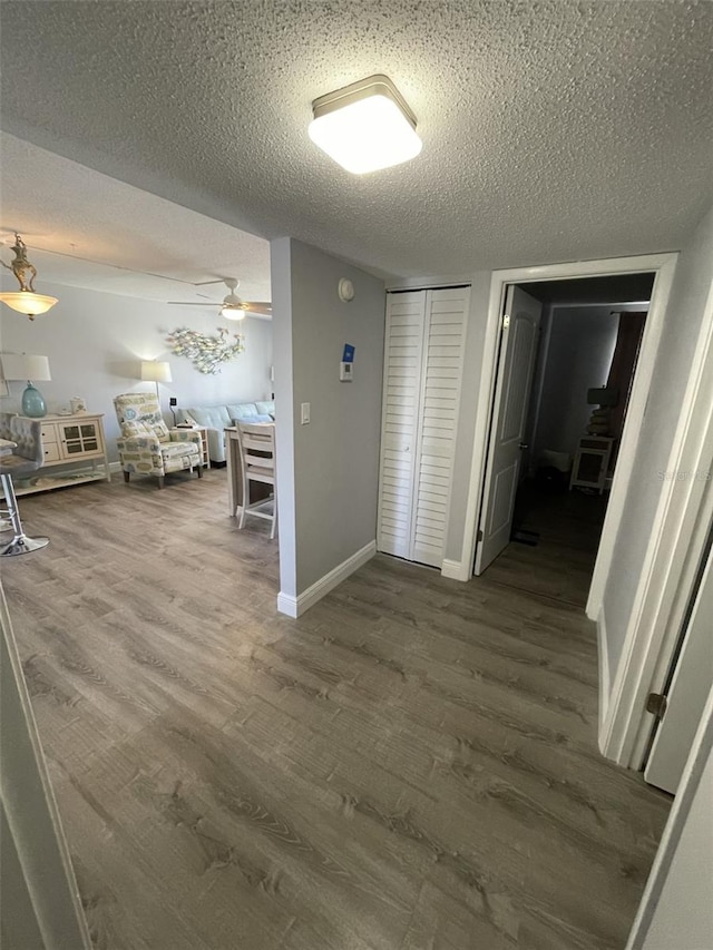 corridor with hardwood / wood-style flooring and a textured ceiling