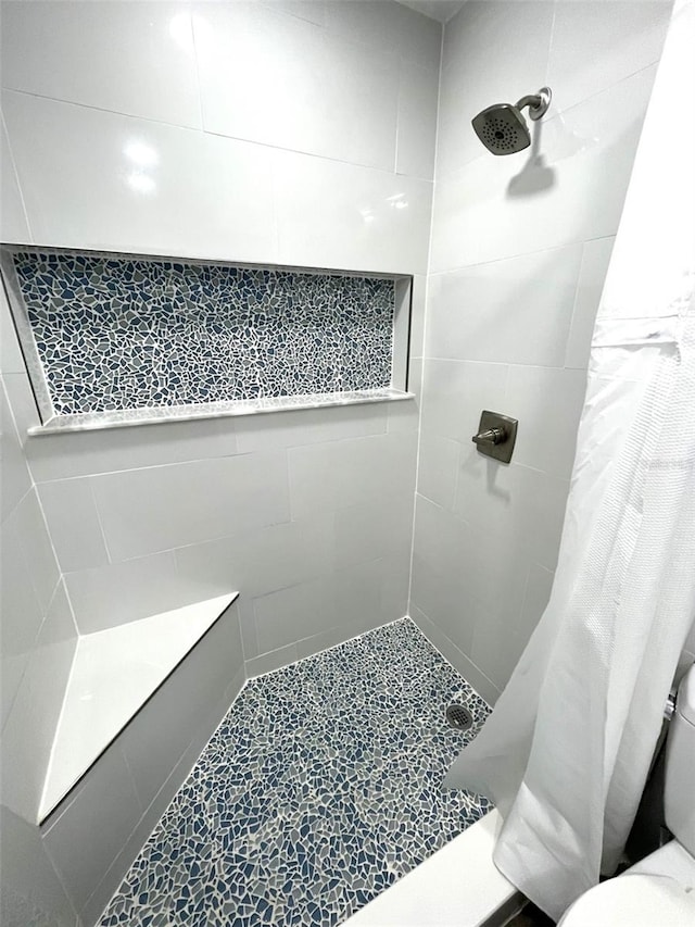 bathroom featuring a shower with curtain and toilet