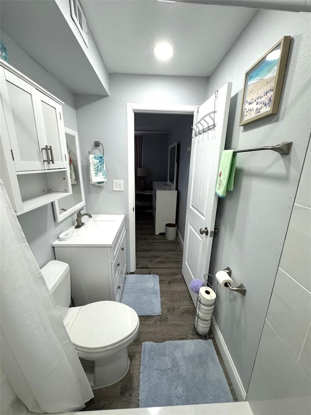 bathroom featuring wood-type flooring, toilet, and vanity