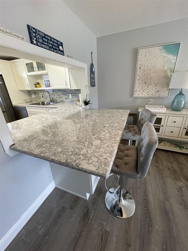 kitchen with sink, a breakfast bar area, and kitchen peninsula