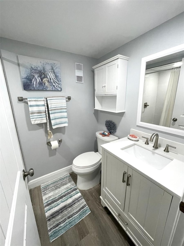 bathroom featuring hardwood / wood-style flooring, vanity, and toilet