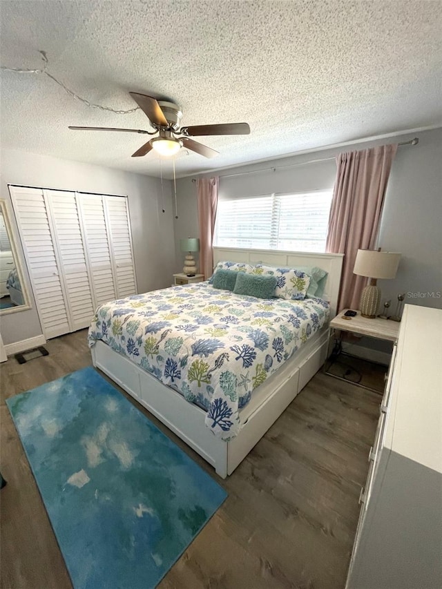 bedroom with dark hardwood / wood-style flooring, ceiling fan, a closet, and a textured ceiling