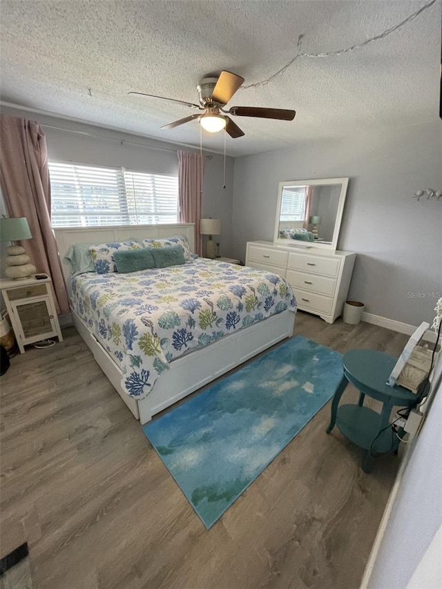 bedroom with hardwood / wood-style flooring, ceiling fan, and a textured ceiling