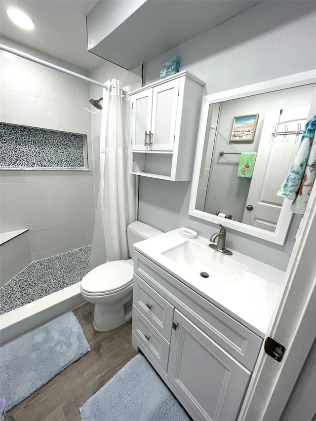 bathroom with toilet, hardwood / wood-style floors, vanity, and a shower with curtain