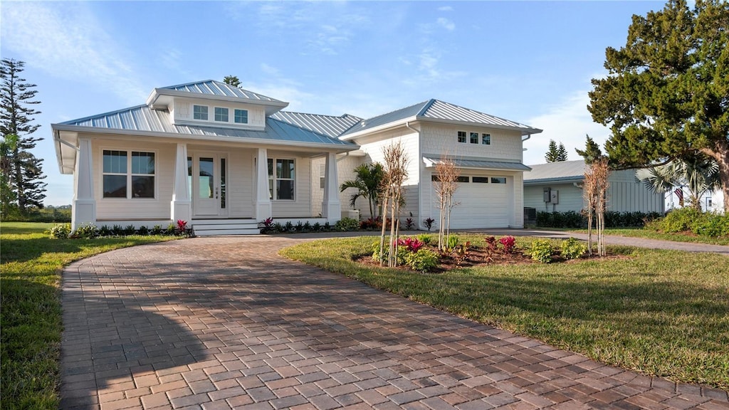 view of front of property featuring a garage, a front yard, and a porch