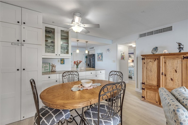 dining room with ceiling fan and light wood-type flooring