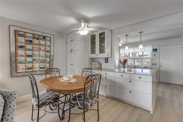 dining space with ceiling fan and light wood-type flooring