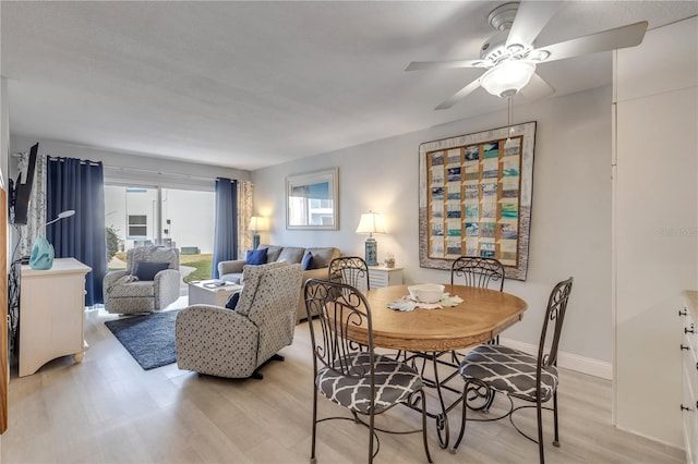 dining room with ceiling fan and light hardwood / wood-style floors