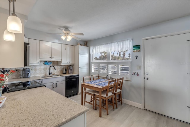 kitchen featuring sink, white cabinetry, decorative light fixtures, black dishwasher, and decorative backsplash