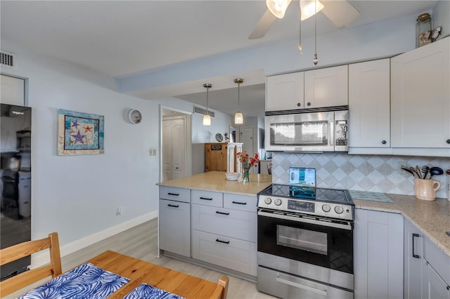 kitchen featuring tasteful backsplash, white cabinets, hanging light fixtures, stainless steel appliances, and light stone countertops