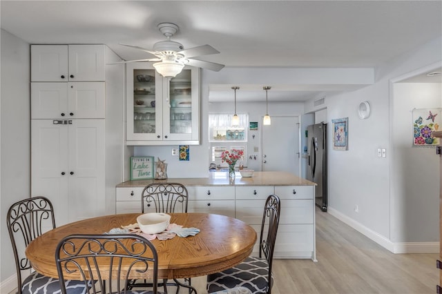 dining area with ceiling fan and light hardwood / wood-style flooring