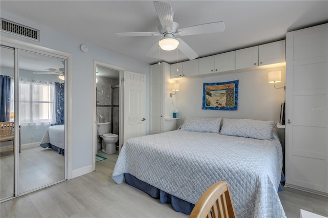 bedroom featuring ceiling fan, a closet, ensuite bathroom, and light hardwood / wood-style flooring