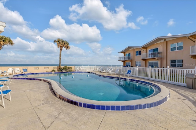 view of swimming pool with a patio and a water view