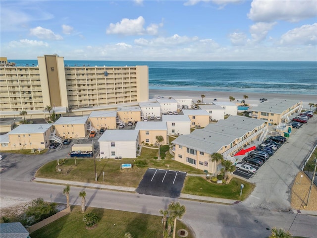 birds eye view of property with a water view and a view of the beach