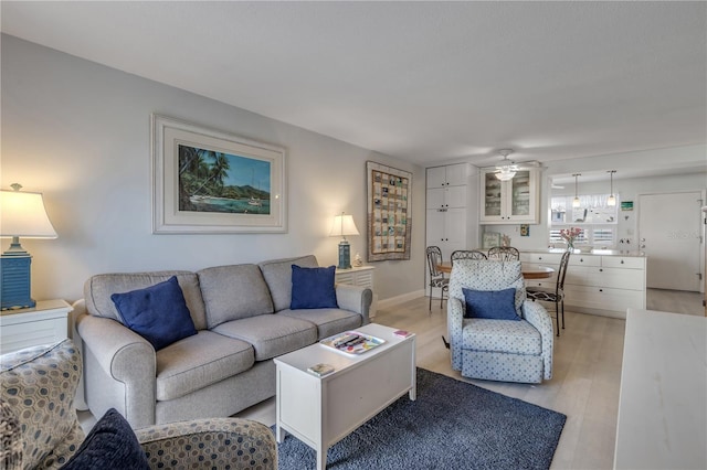 living room with ceiling fan and light hardwood / wood-style floors