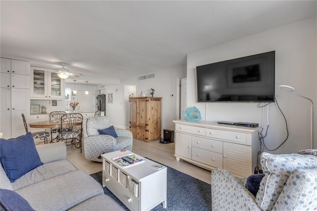 living room featuring ceiling fan and light hardwood / wood-style flooring