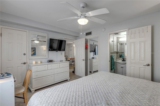 bedroom with ceiling fan, ensuite bath, and light wood-type flooring