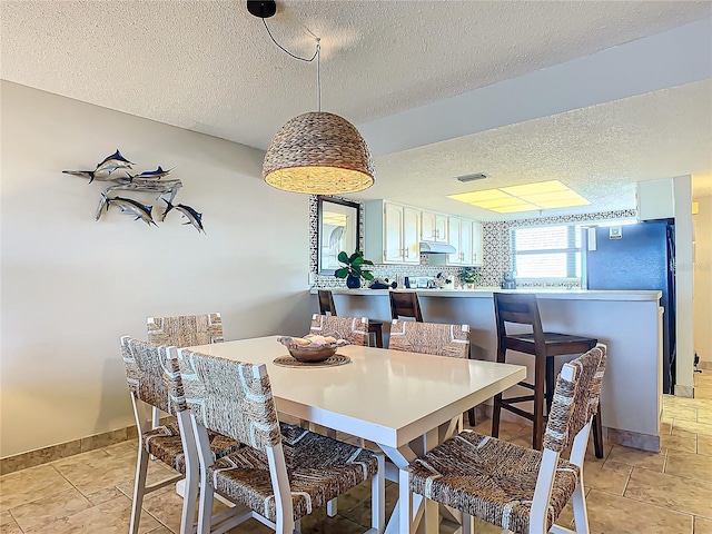 dining area featuring a textured ceiling