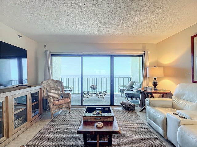 tiled living room with a water view and a textured ceiling