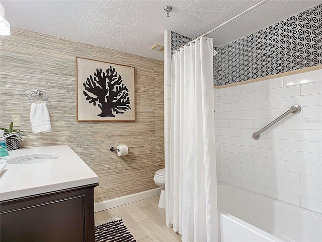 full bathroom with hardwood / wood-style floors, vanity, shower / bath combination with curtain, a textured ceiling, and toilet