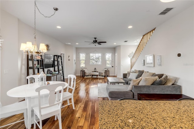 dining area featuring wood-type flooring and ceiling fan with notable chandelier