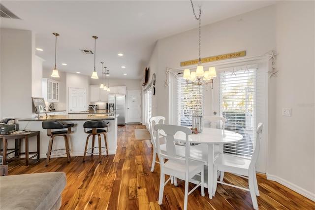 dining space with hardwood / wood-style floors and a chandelier