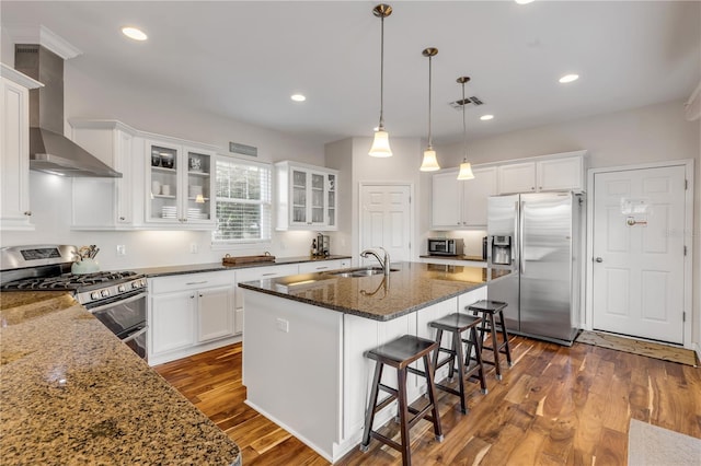 kitchen with a kitchen island with sink, sink, white cabinetry, and appliances with stainless steel finishes