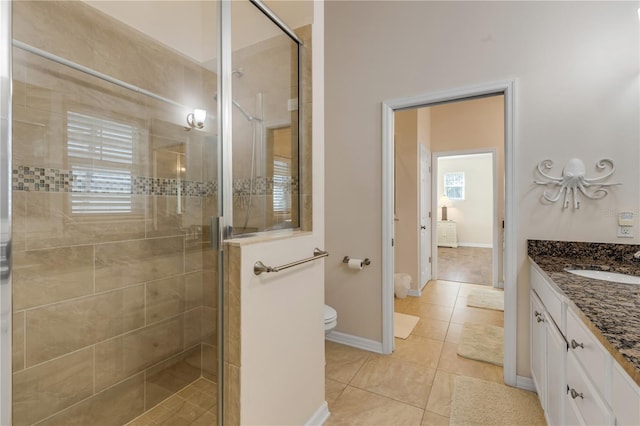 bathroom with tile patterned floors, vanity, toilet, and a shower with shower door