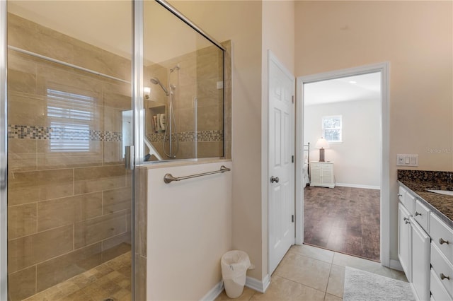 bathroom featuring walk in shower, vanity, and tile patterned flooring