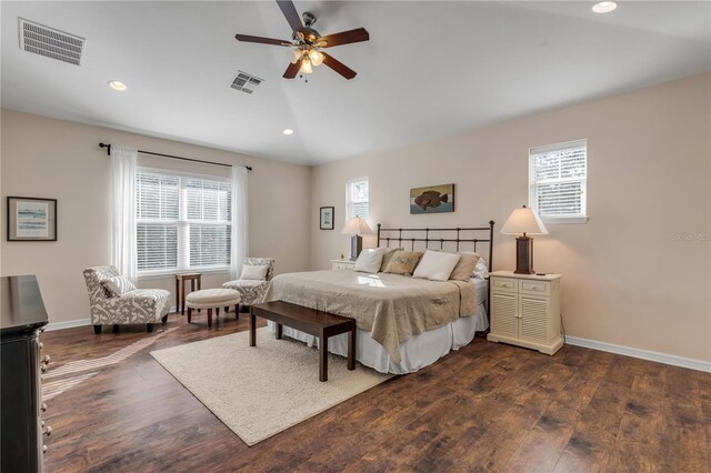 bedroom featuring multiple windows, dark wood-type flooring, vaulted ceiling, and ceiling fan