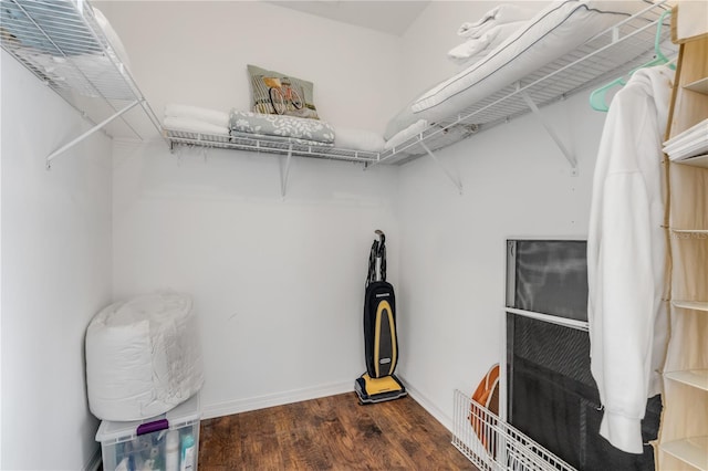 walk in closet with dark wood-type flooring