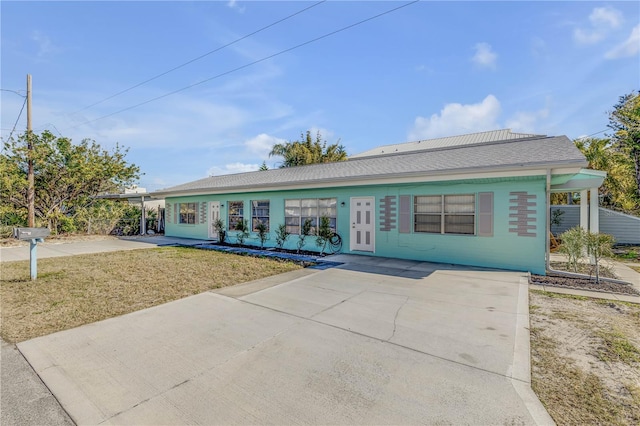 ranch-style home with a carport and a front lawn