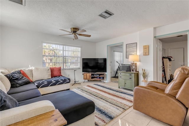 tiled living room featuring ceiling fan and a textured ceiling