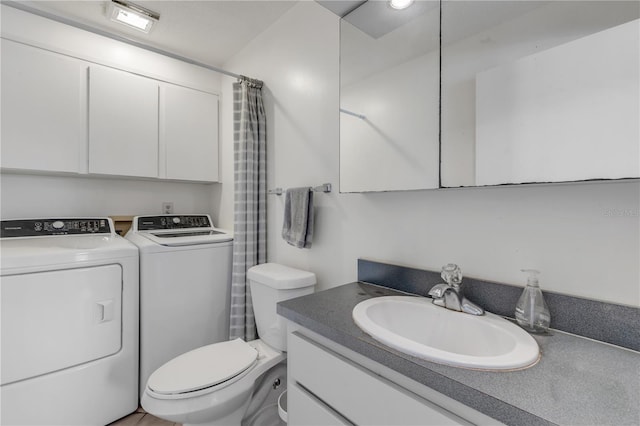 bathroom with washing machine and dryer, curtained shower, vanity, and toilet