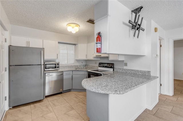 kitchen with appliances with stainless steel finishes, sink, white cabinets, and kitchen peninsula