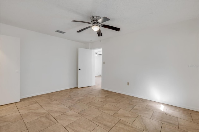 tiled spare room featuring ceiling fan