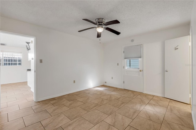 empty room with a textured ceiling and ceiling fan