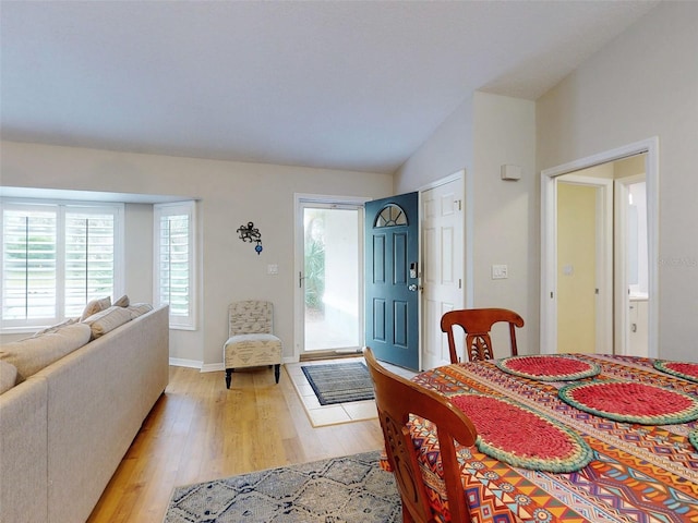 dining room with vaulted ceiling and light wood-type flooring