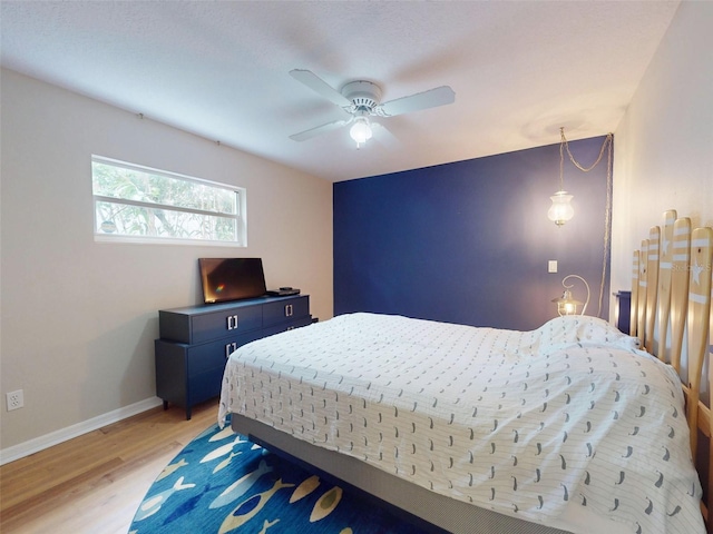 bedroom with light hardwood / wood-style floors and ceiling fan