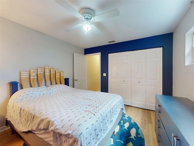 bedroom featuring ceiling fan, a closet, and light wood-type flooring