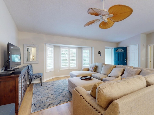 living room featuring lofted ceiling, ceiling fan, and light wood-type flooring