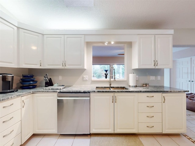 kitchen featuring white cabinetry, sink, stainless steel dishwasher, and light stone countertops