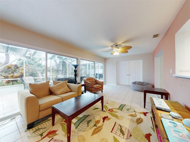 living room featuring light tile patterned floors, a textured ceiling, and ceiling fan