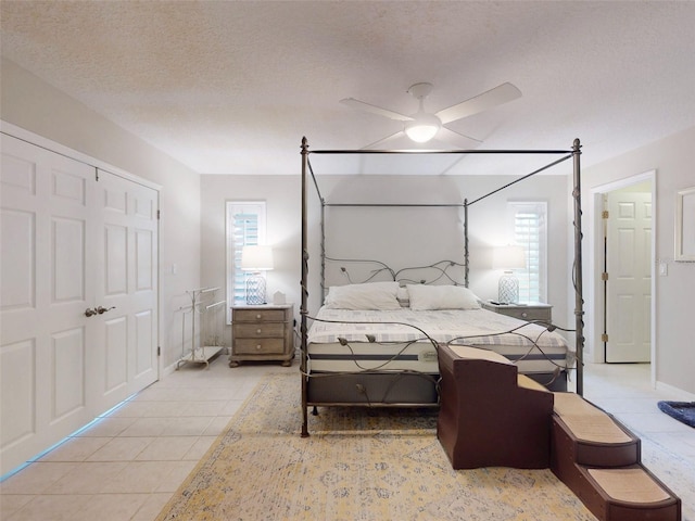 tiled bedroom featuring ceiling fan and a textured ceiling