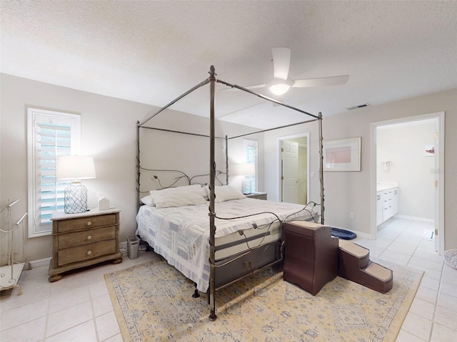 bedroom with light tile patterned floors, ensuite bath, a textured ceiling, and ceiling fan