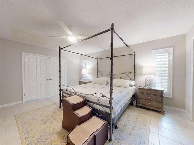 tiled bedroom featuring ceiling fan and a textured ceiling